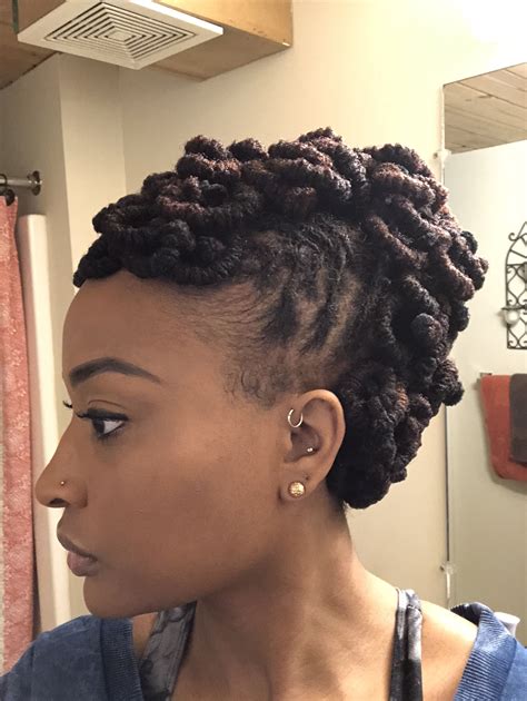 Two twisted loc side burns are left to create softness on the face. . Updo hairstyles for locs